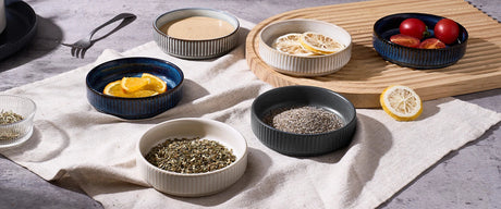 Small ceramic serving bowls arranged with snacks on a table