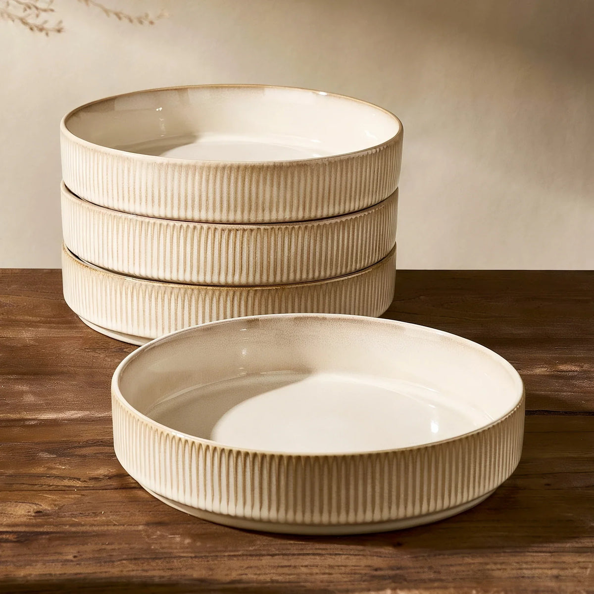 Four oatmeal-colored Famiware bowls stacked on a wooden table