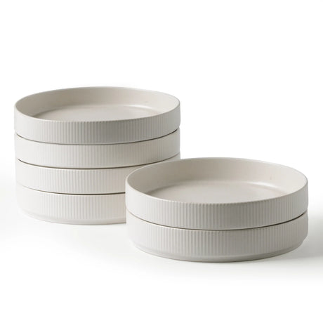 White wide ceramic bowls stacked to show their shallow sides and open interiors