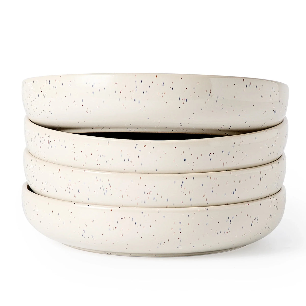 Four wide white speckled ceramic bowls stacked on a white background