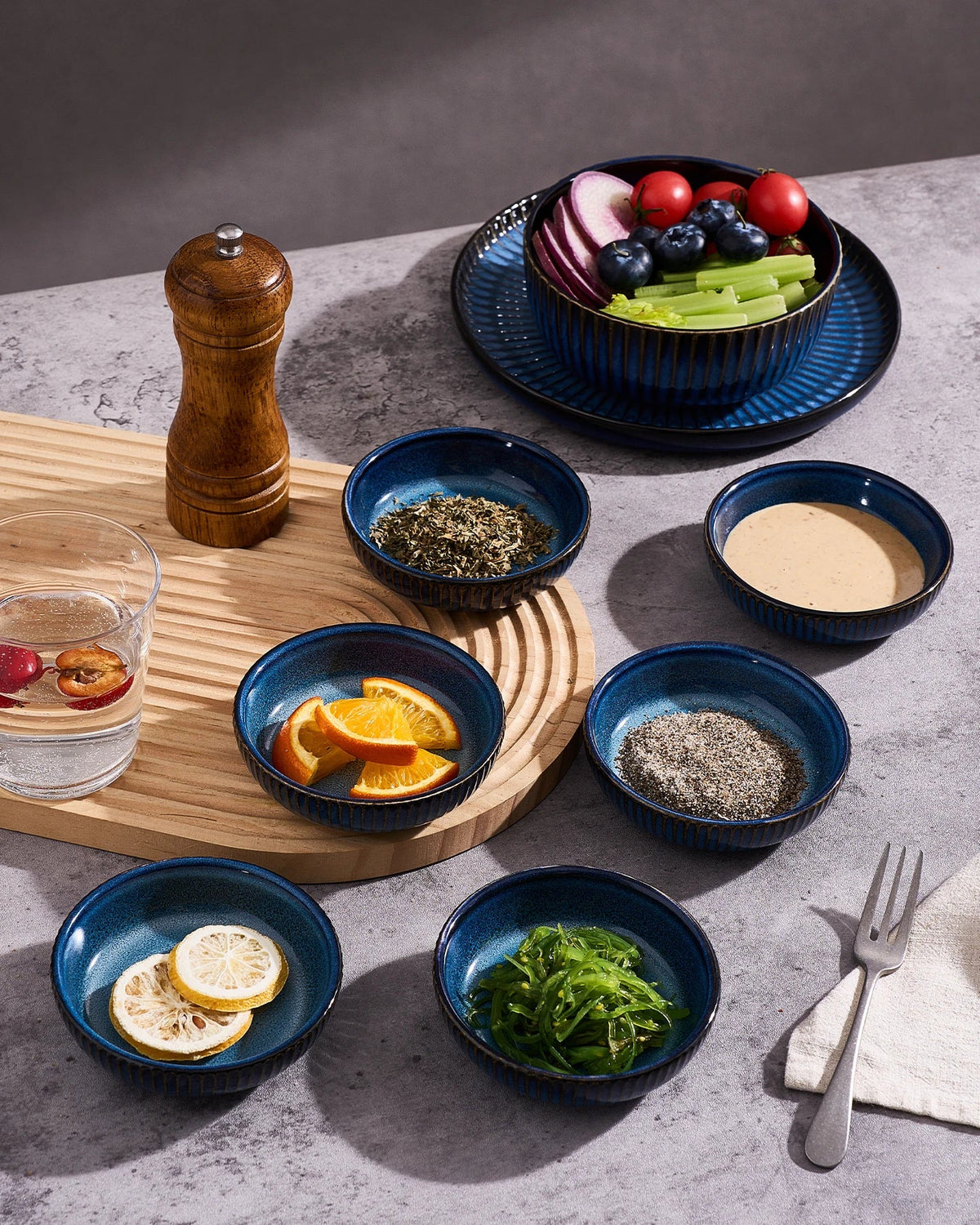 Blue ceramic side dishes holding seasonings and sauces