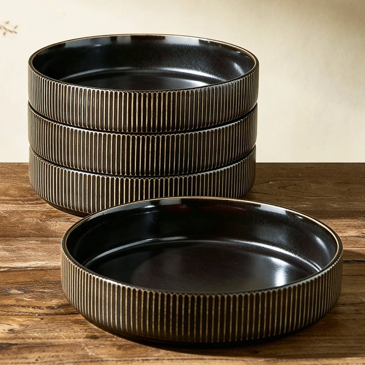 Dark ribbed ceramic bowls with wide openings on a wooden table