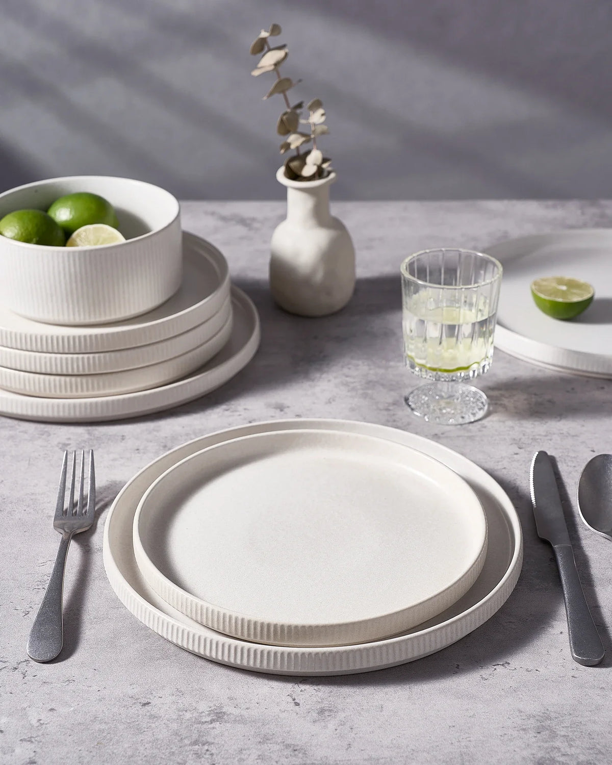 White Famiware plates beside stainless-steel flatware