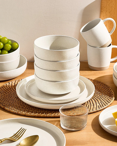 Neatly stacked neutral stoneware bowls and plates